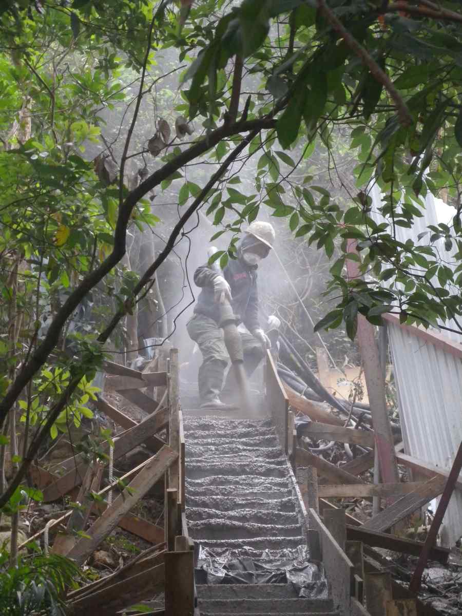 looks like a female construction worker, very common here, juxtaposition of plants and concrete, a summary of the city